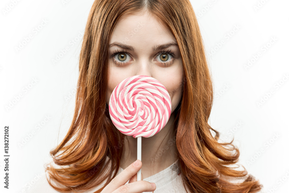 round lollipop in front of a woman's face