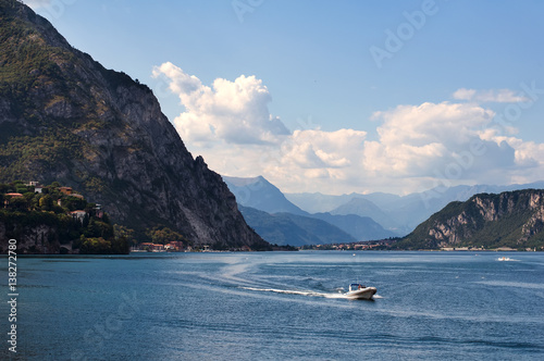 Il panorama sul lago tra le montagne con una barca a motore in movimento a Lecco, regione Lombardia, Italia 