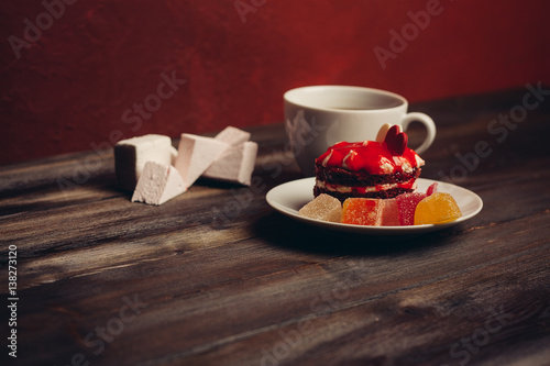 cup with a drink  marshmallow and cake with colorful pieces of marmalade