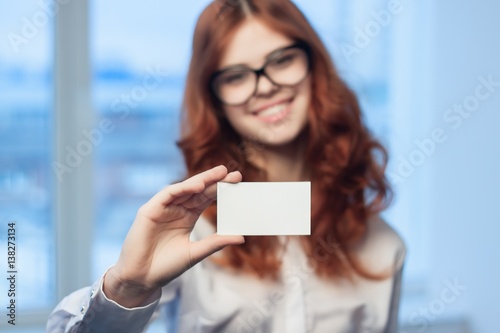 Business woman with glasses shows a badge in the camera