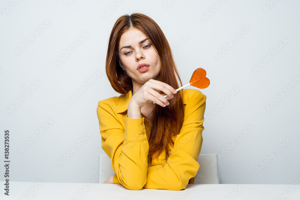 a lollipop in the form of a heart, a yellow shirt, a sleepy woman a lollipop in the form of a heart, a yellow shirt, a sleepy woman