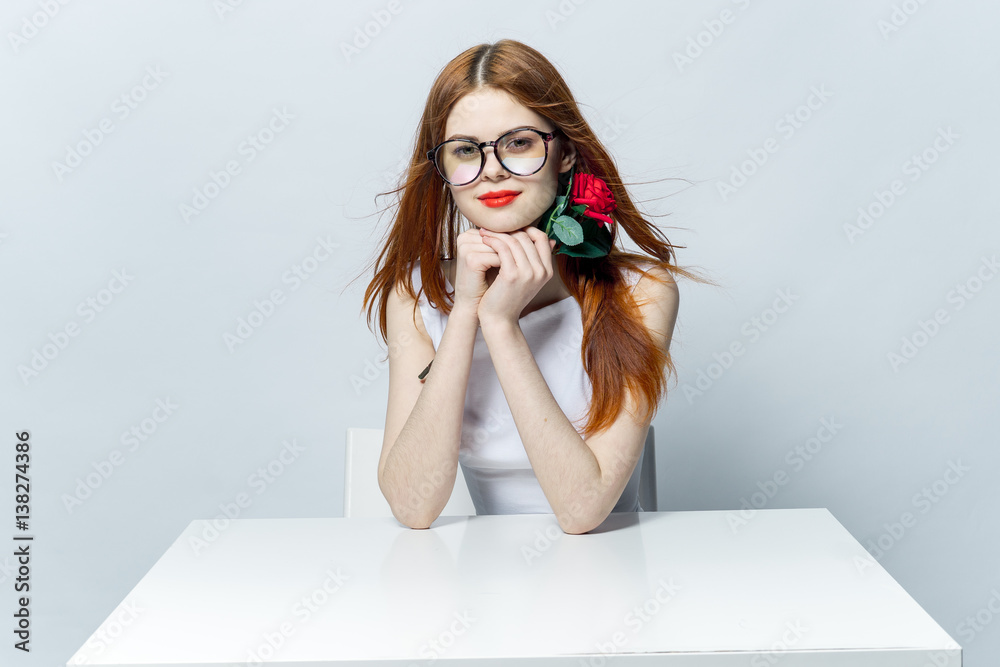 woman with red flower sitting at table woman with red flower sitting at table