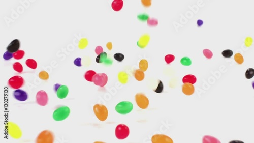 Jelly beans fall in slow motion onto a white cyc