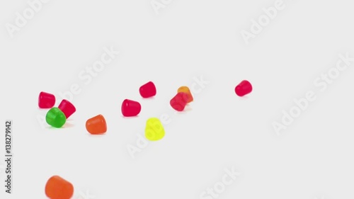 Gummy candy tumble and fall in slow motion onto a white cyc
