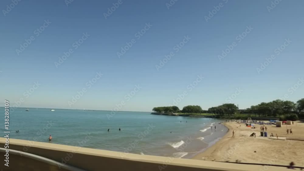 Driving by a beach near Midtown Chicago featuring swimmers, joggers and bikers Driving by a beach near Midtown Chicago featuring swimmers, joggers and bikers