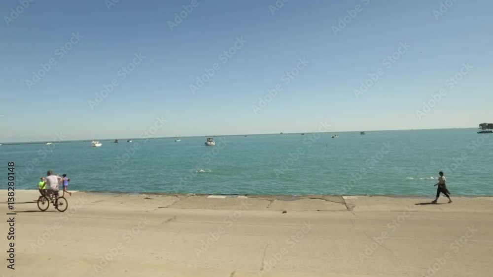 Summertime at Chicago Beach featuring bikers, boaters, and swimmers Summertime at Chicago Beach featuring bikers, boaters, and swimmers