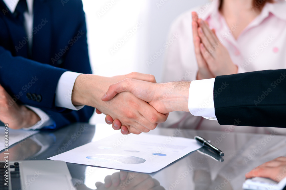 Business people shaking hands finishing up a meeting Business people shaking hands finishing up a meeting