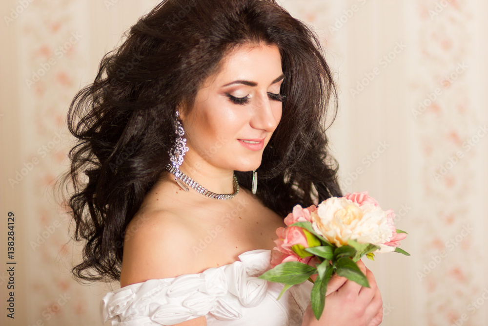 Studio portrait of a beautiful young woman. Brunette girl with hairstyle, wearing like bride. She in white corset with accessories Studio portrait of a beautiful young woman. Brunette girl with hairstyle, wearing like bride. She in white corset with accessories