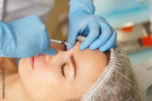 Injections under the skin. The injection the skin above the eyebrow. Injection of beauty. Spa. Facial Rejuvenation. Removal of wrinkles.