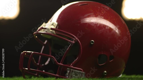 A football helmet spins to show face mask under the stadium lights.