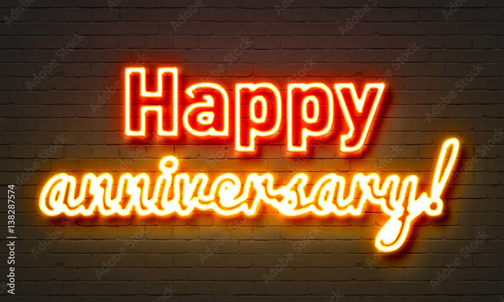 Happy anniversary neon sign on brick wall background. Stock