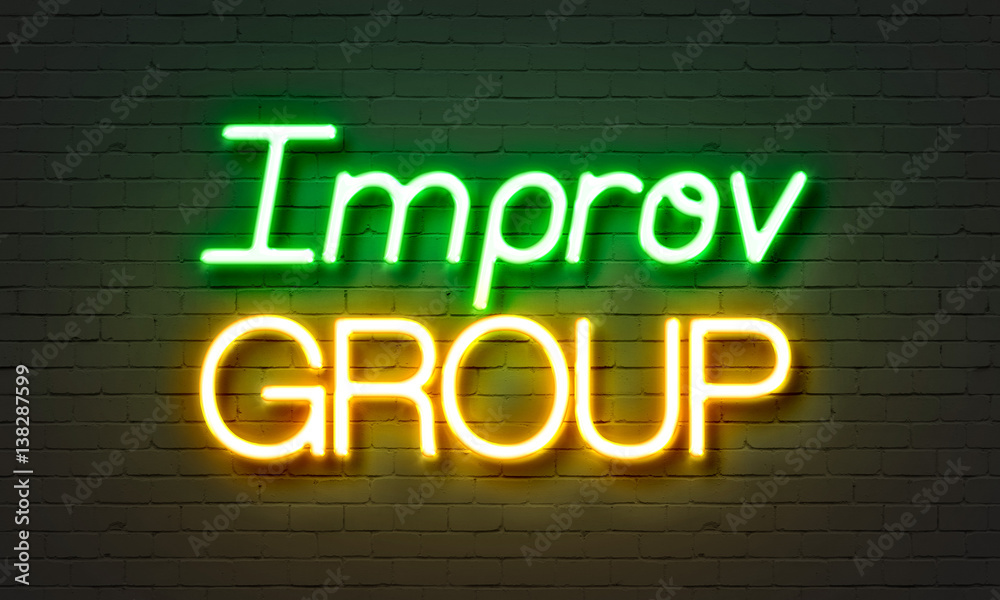 Improv group neon sign on brick wall background.