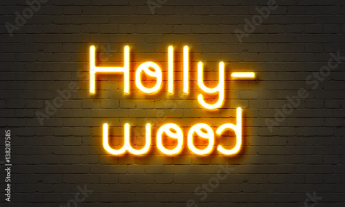 Hollywood neon sign on brick wall background.