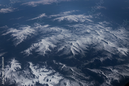 View from airplane on Earth surface - snow-capped mountains.