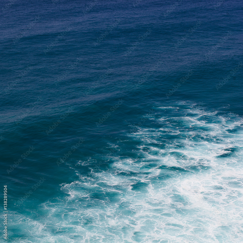 Indian ocean texture. Turquoise sea water with white foam. Powerful and peaceful nature concept.