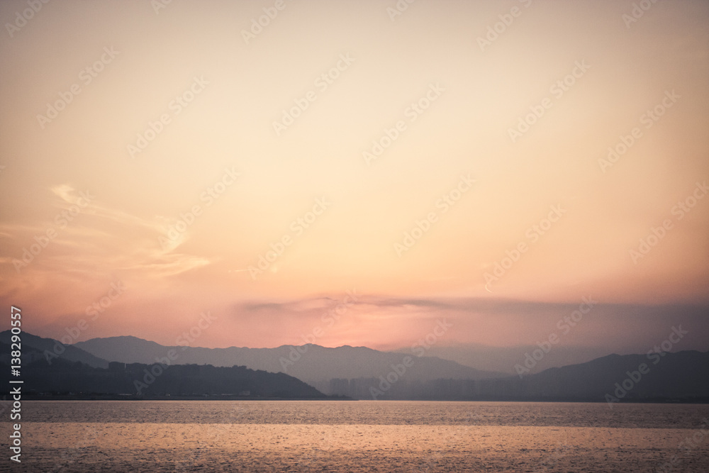 Sunset with sea and distant mountains