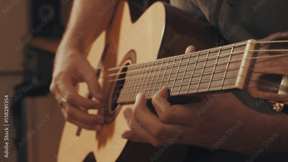 Fototapeta premium Hands of guitarist playing a guitar