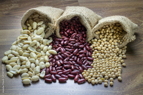 Assortment of beans and lentils in hemp sack on wooden background. , groundnut, soybean, red kidney bean ,red bean and brown pinto beans