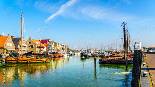 Sail boats and motor boats moored in a part of the harbor overtaken by algae in the historic fishing village of Urk in the Netherlands photo