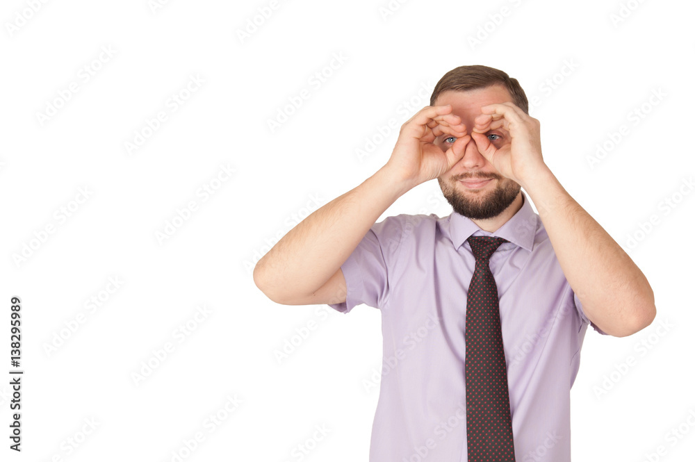 Handsome young man smiling, making binoculars with his hands.