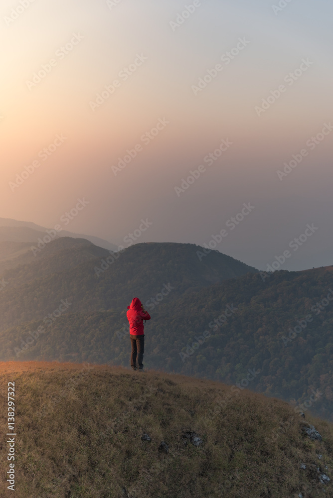 Woman on the top of mountain with sunlight in the morning