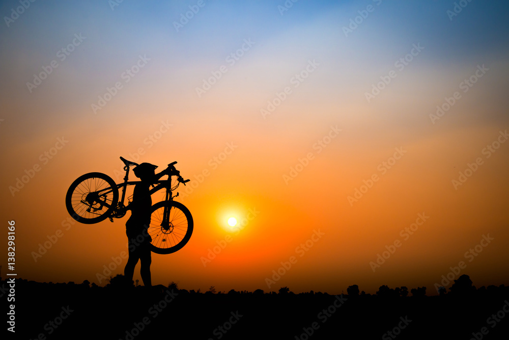 Fototapeta premium Silhouette of young man cyclist on sunset.