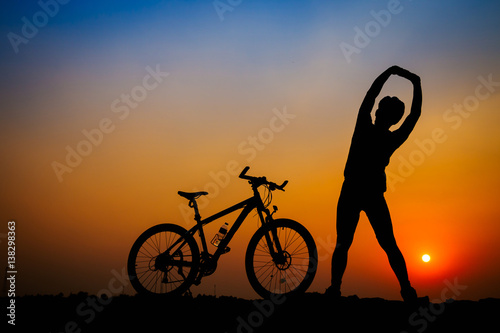 Silhouette of young man cyclist on sunset.