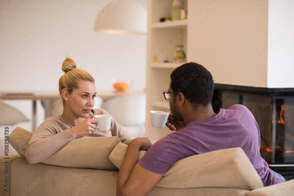 Young multiethnic couple in front of fireplace Young multiethnic couple in front of fireplace