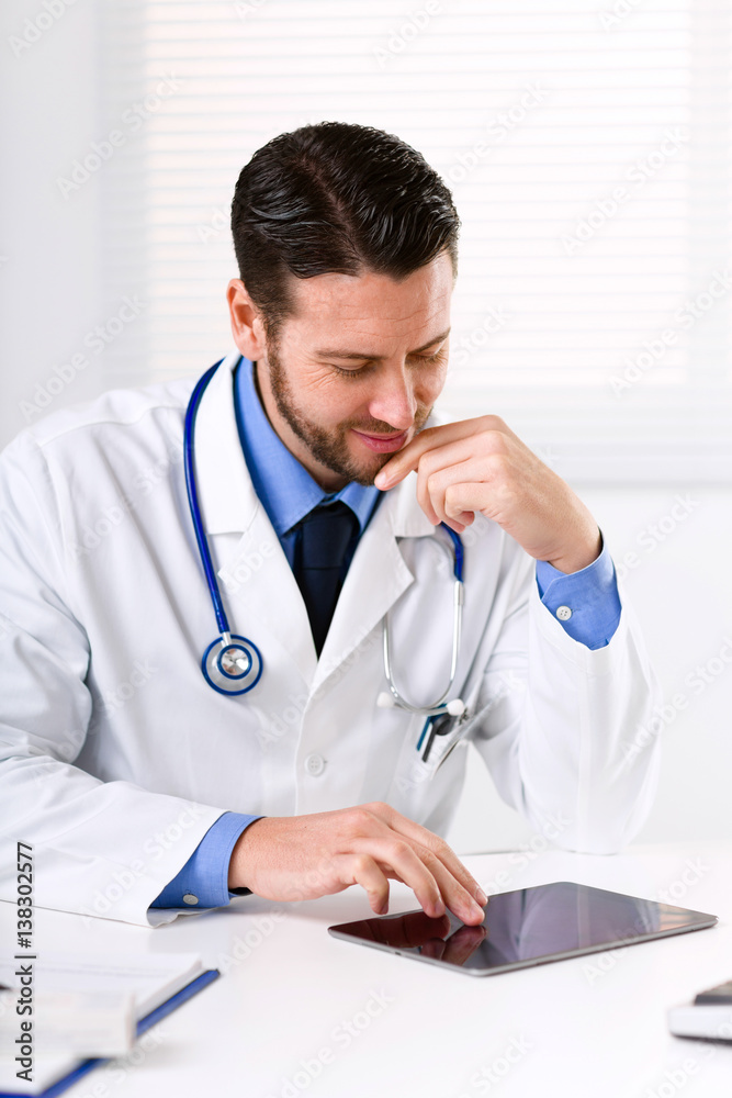 Doctor at table working with tablet Doctor at table working with tablet