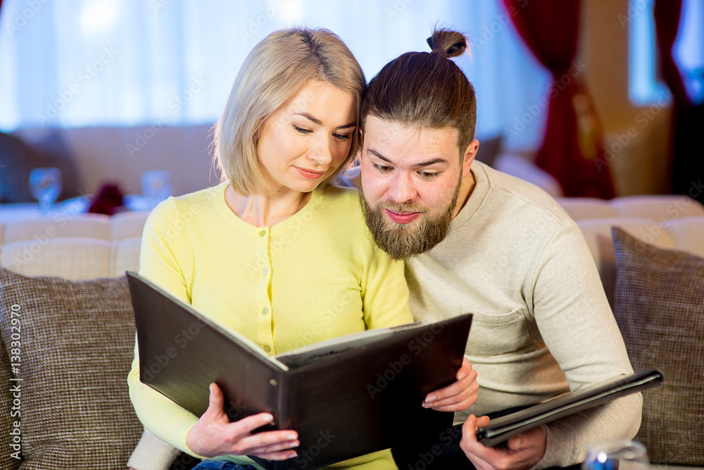 couple reading a menu in a restaurant couple reading a menu in a restaurant