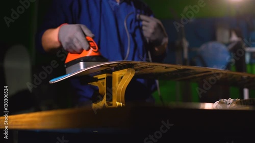 Grind edge on a snowboard in the service. Paraffin board. snowboard repair