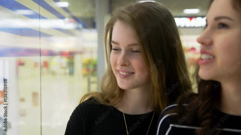 Excited girl admiring the view in the shop window Excited girl admiring the view in the shop window
