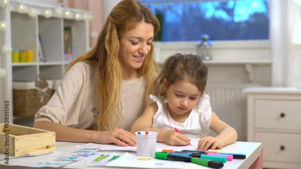 Happy family. Mother and daughter are learning to write. Adult woman teaches child the alphabet. Happy family. Mother and daughter are learning to write. Adult woman teaches child the alphabet.