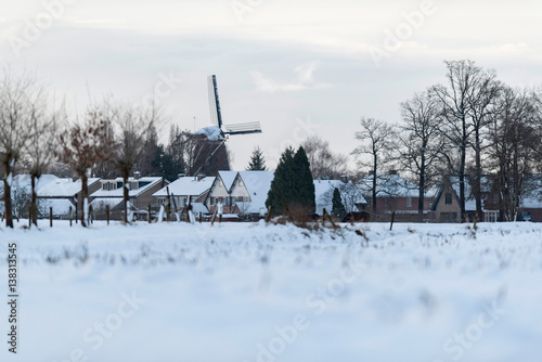 Dutch rural village with windmill in snow. Geesteren. Achterhoek. Gelderland. The Netherlands.