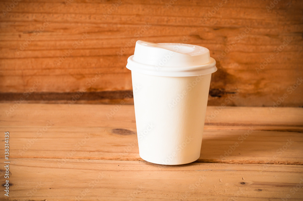 paper cup of coffee on wooden table background paper cup of coffee on wooden table background