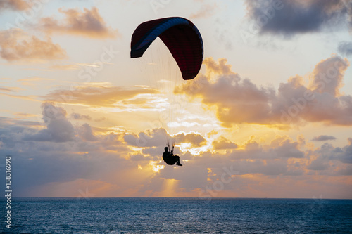 Person on parachute in sunset photo