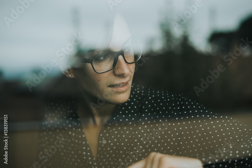 Chica mirando por la ventana photo