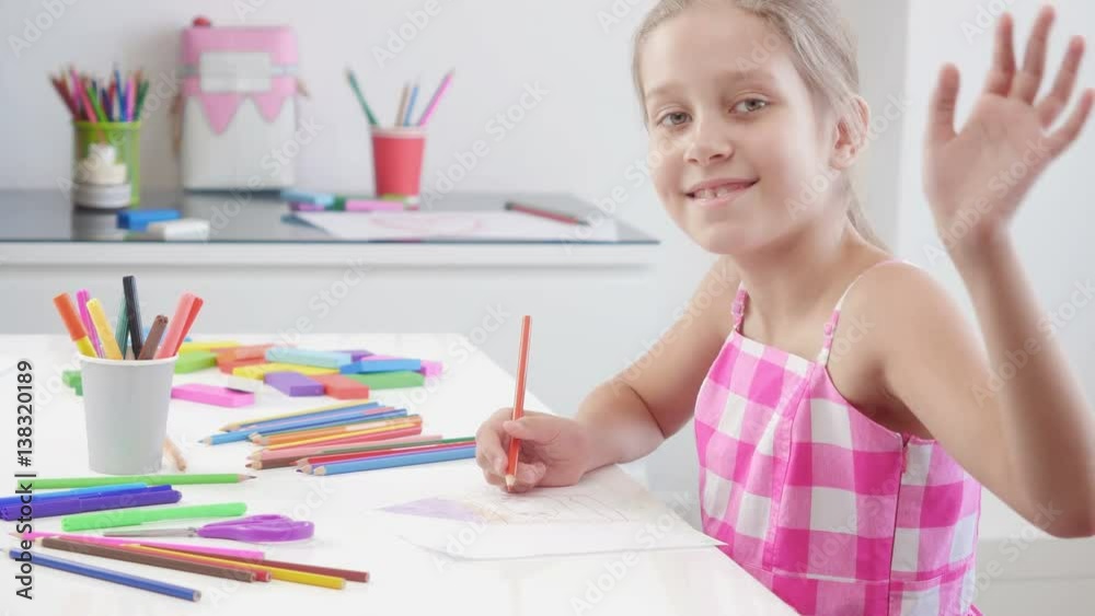 White 7 years old girl drawing and coloring on a paper at home. Girl looking at camera and smiling.
White 7 years old girl drawing and coloring on a paper at home. Girl looking at camera and smiling.