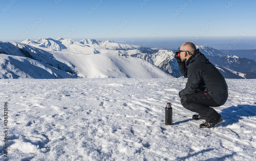 Tourists drink hot tea in the mountains.