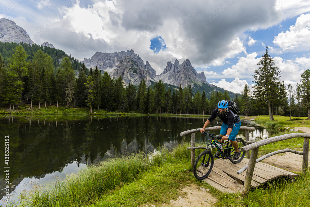 Mountain biking in the Dolomites, Misurina, Italy. Tre Cime di Lavaredo in background.