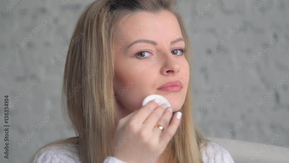 girl Making her face clean and fresh. Beautiful young woman wiping her face with sponge. girl Making her face clean and fresh. Beautiful young woman wiping her face with sponge.