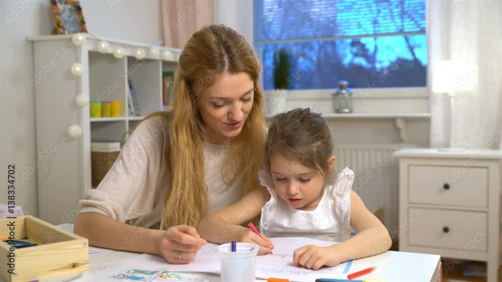 Happy family. Mother and daughter are learning to write. Adult woman teaches child the alphabet. Happy family. Mother and daughter are learning to write. Adult woman teaches child the alphabet.