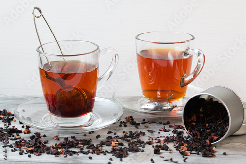 Black tea with spices.Strainer. Grey wooden background.