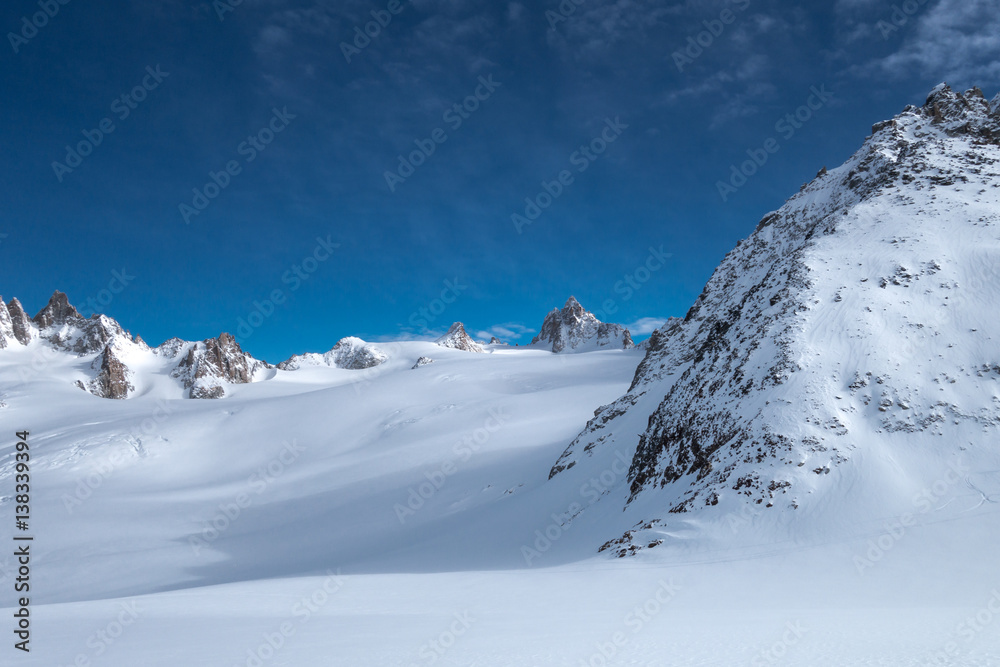 Snow covered alpine glacier vistas under blue sky after snowfall