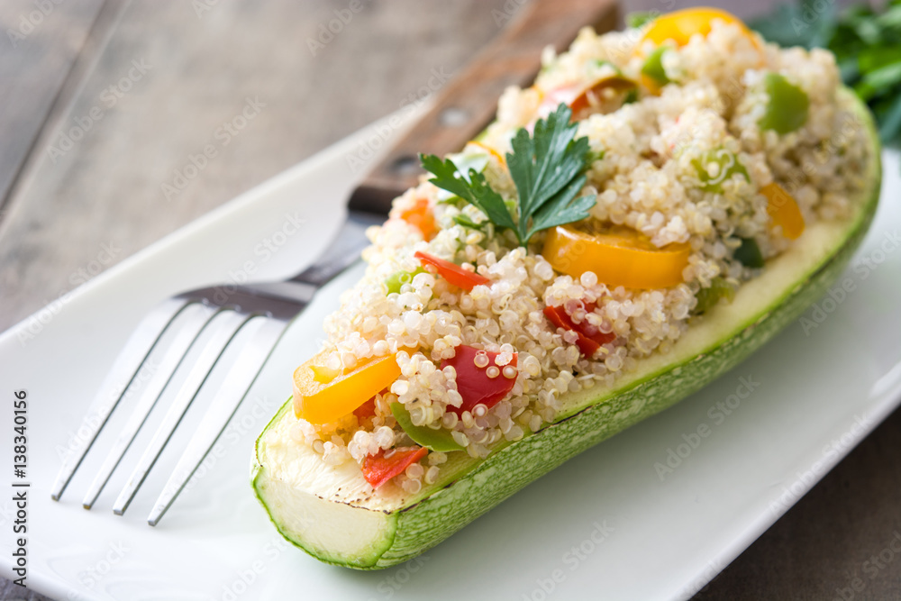 Stuffed zucchini with quinoa and vegetables on wooden background
Stuffed zucchini with quinoa and vegetables on wooden background