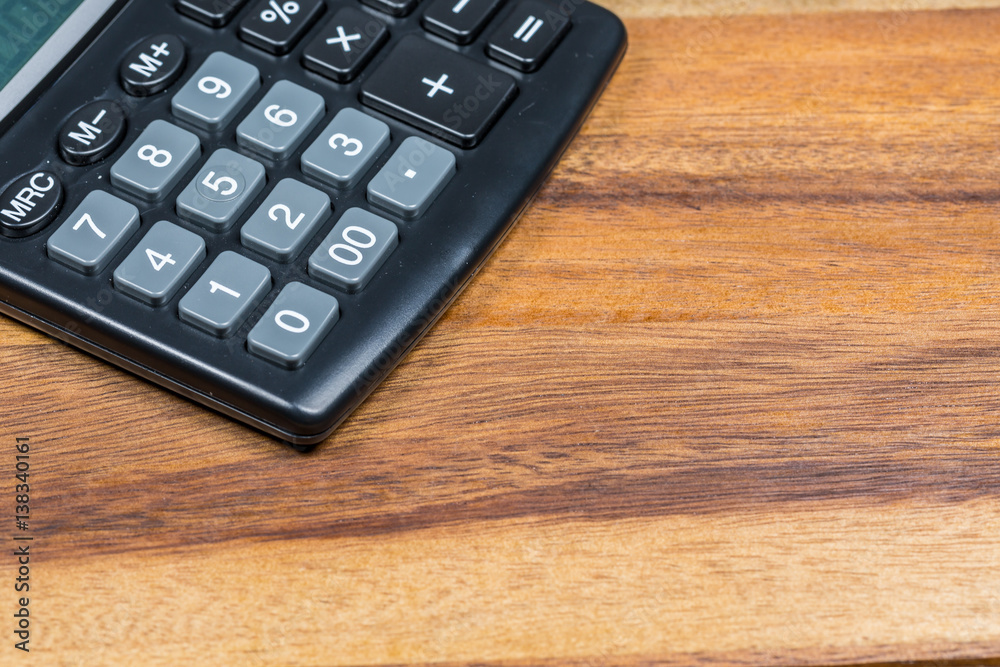 Calculator lie on the surface of a wooden table Calculator lie on the surface of a wooden table