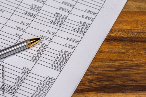 Finansical chart and pen on wooden table