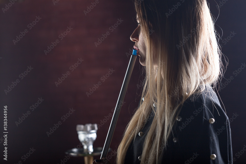 Fototapeta premium Young, beautiful girl smokes a hookah