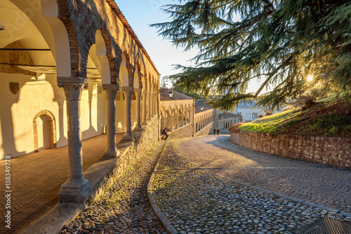 Colonnade and ancient path in the castle of Udine under the sunset light photo