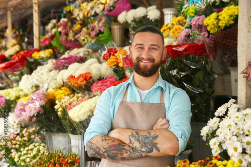 Handsome tattooed florist in flower shop